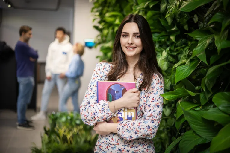 Czy studia podyplomowe są trudne? Czy warto i czy mają sens? | Uniwersytet WSB Merito: Dziewczyna z notesem na zielonym tle