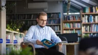 Master of Business Administration | Uniwersytet WSB Merito Łódź: uczestnik mba czyta książkę w bibliotece 