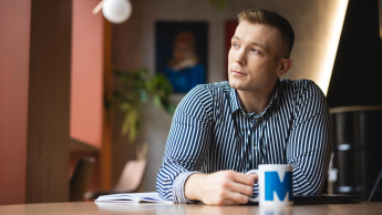 Administracja i bezpieczeństwo wewnętrzne | Uniwersytet WSB Merito Łódź: Student pije kawę w trakcie przerwy z kubka Uniwersytetu WSB Merito w Łodzi