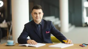 Student Uniwersytetu WSB Merito w Łodzi pozuje do zdjęcia.