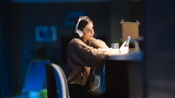 Tester oprogramowania dla aplikacji mobilnych i serwerowych z zastosowaniem AI | Studia podyplomowe w Łodzi | Uniwersytet WSB Merito Łódź: Studentka Uniwersytetu WSB Merito w Łodzi słucha muzyki