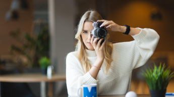 Social media i influencer marketing | Uniwersytet WSB Merito Łódź: Studentka pozuje z aparatem do zdjęcia.