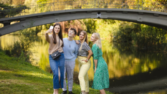 Projektowanie UX I UI | Studia I stopnia w Łodzi | Uniwersytet WSB Merito Łódź: Studenci Uniwersytetu WSB Merito pozują do selfie w parku.