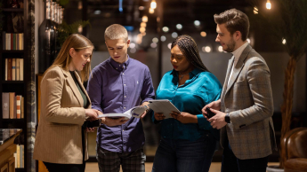 Marketing w nowych mediach | Studia II stopnia ze studiami podyplomowymi  | Uniwersytet WSB Merito Łódź: Grupa studentów rozmawia nad dokumentami.