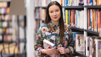 Studentka Uniwersytetu WSB Merito w Łodzi pozuje do zdjęcia.