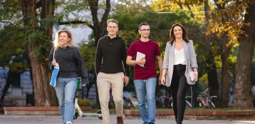 Zasady rekrutacji | Uniwersytet WSB Merito Łódź: 4 studentów Uniwersytetu WSB Merito w Łodzi w wesołej atmosferze idzie przez park