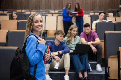 Aktualności | Uniwersytet WSB Merito Łódź: Grupka studentów siedzi i rozmawia w auli.