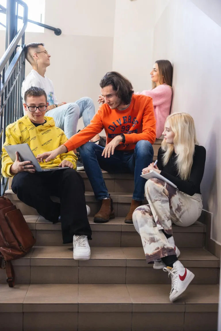 Poznaj nas | Uniwersytet WSB Merito Łódź: Studenci na klatce schodowej Uniwersytetu WSB Merito Łódź