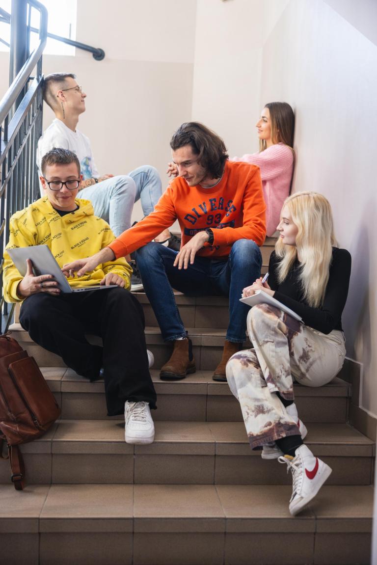 Poznaj nas | Uniwersytet WSB Merito Łódź: Studenci na klatce schodowej Uniwersytetu WSB Merito Łódź