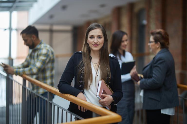 Stypendia i zniżki | Uniwersytet WSB Merito Łódź: Studentka Uniwersytetu WSB Merito w Łodzi idzie na zajęcia