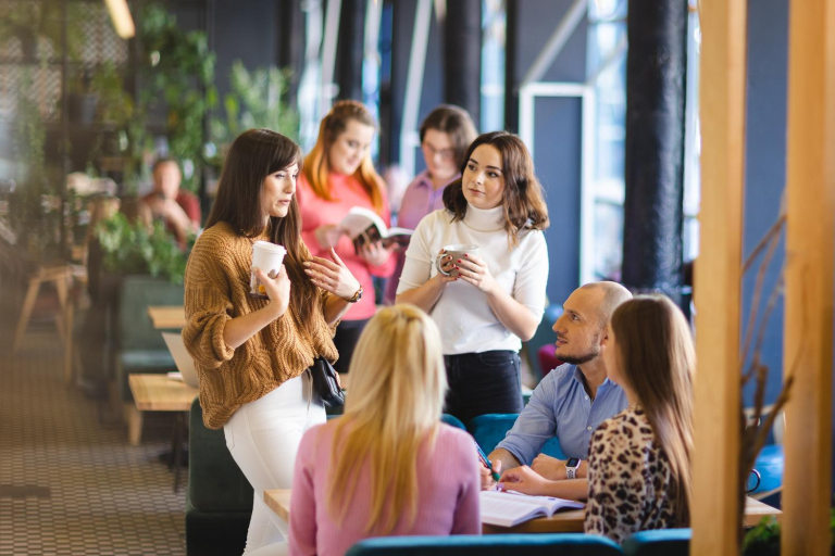 Programista JavaScript z wykorzystaniem AI | Studia podyplomowe w Łodzi | Uniwersytet WSB Merito Łódź: Grupa ludzi rozmawia przy stole.