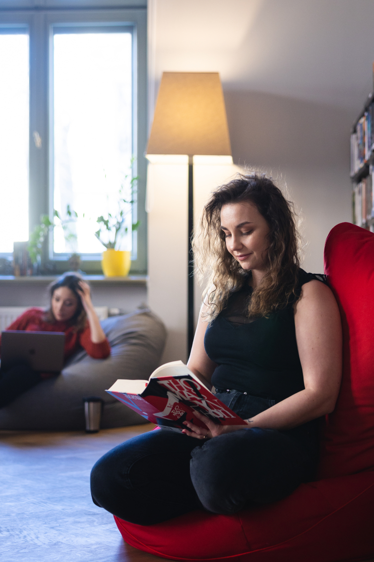 Rachunkowość przedsiębiorstw i kontrola finansowa | Studia II stopnia ze studiami podyplomowymi  | Uniwersytet WSB Merito Łódź: Studentka Uniwersytetu WSB Merito w Łodzi czyta książkę.