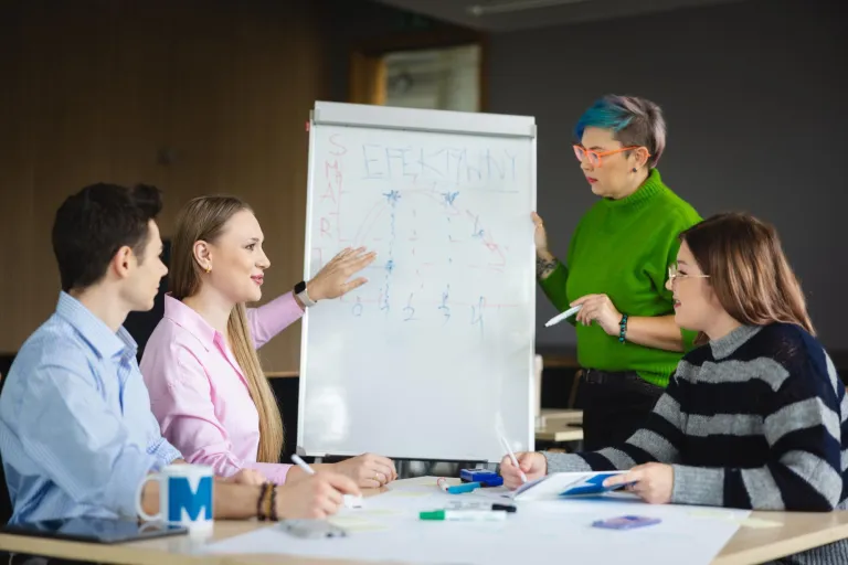 Marketing in the digital economy | Uniwersytet WSB Merito Łódź: Czwórka osób analizuje wykres na tablicy.