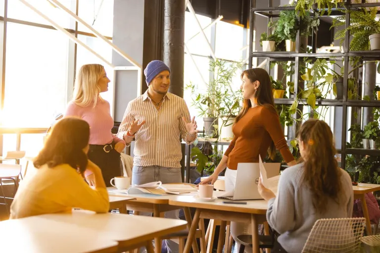 Zarządzanie w branży kosmetycznej i dietetycznej | Studia II stopnia ze studiami podyplomowymi  | Uniwersytet WSB Merito Łódź: Piątka studentów rozmawia nad dokumentami i notatkami.