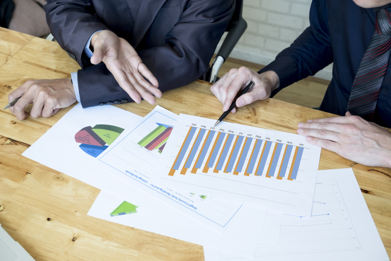 Intelligent automation | Studia podyplomowe w Opolu | Uniwersytet WSB Merito Opole: Dwie osoby omawiają wykres słupkowy na kartce 