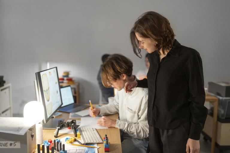 Zarządzanie zespołami rozproszonymi | Studia podyplomowe w Opolu | Uniwersytet WSB Merito Opole: Dwie osoby pracują przy projektcie przed komputerem