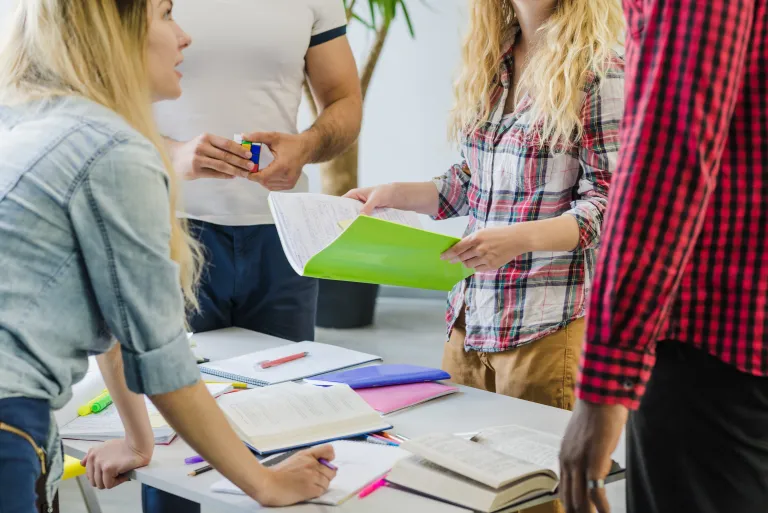 Zarządzanie zasobami ludzkimi w małej firmie | Studia podyplomowe w Opolu | Uniwersytet WSB Merito Opole: Studenci pracują wspólnie, przeglądając materiały i zapisując notatki