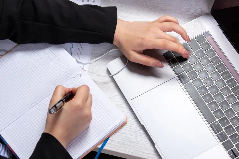 Neuroprzywództwo | Studia podyplomowe w Opolu | Uniwersytet WSB Merito Opole: Osoba robiąca notatki i pracująca przy komputerze