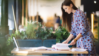 E-Public Relations i creative writing | Studia I stopnia w Opolu | Uniwersytet WSB Merito Opole: Dziewczyna w kwiecistej sukience pracuje nad projektem.