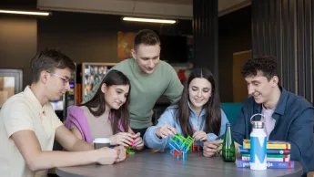 Pedagogika opiekuńczo-wychowawcza z neuropedagogiką | Uniwersytet WSB Merito Opole: Grupa młodych ludzi buduje klocki w ramach projektu