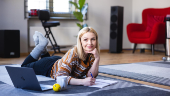 Praca z osobami niedostosowanymi społecznie z profilaktyką uzależnień | Studia I stopnia w Opolu | Uniwersytet WSB Merito Opole: Główna grafika: Opole - specjalność Praca z osobami niedostosowanymi społecznie z profilaktyką uzależnień - kobieta leżąca na dywanie a przed nia komputer 