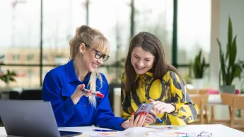 Zarządzanie projektem – Akademia Project Managera | Studia podyplomowe w Opolu | Uniwersytet WSB Merito Opole: Główna grafika: Opole - studia podyplomowe - Zarządzanie projektem – Akademia Project Managera - Dwie kobiety przeglądające notatki