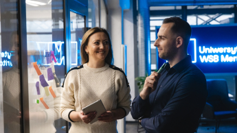 Tworzenie aplikacji internetowych i mobilnych | Studia podyplomowe w Opolu | Uniwersytet WSB Merito Opole: Główna grafika: Opole - studia podyplomowe - Tworzenie aplikacji internetowych i mobilnych -  Dwie osoby przyglądające się notatkom na karteczkach samoprzylepnych