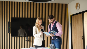 Event Manager | Uniwersytet WSB Merito Opole: Główna grafika: Opole - studia podyplomowe - Dwie osoby przeglądające informator 