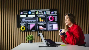 Social media i influencer marketing | Studia podyplomowe w Opolu | Uniwersytet WSB Merito Opole: Główna grafika: Opole - studia podyplomowe - Social media i influencer marketing - Kobieta siedząca przy biurku z kubkiem kawy