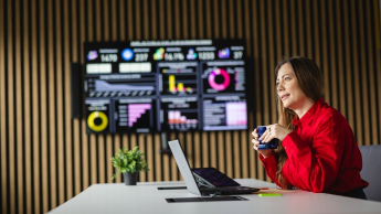 Social media i influencer marketing | Uniwersytet WSB Merito Opole: Główna grafika: Opole - studia podyplomowe - Social media i influencer marketing - Kobieta siedząca przy biurku z kubkiem kawy