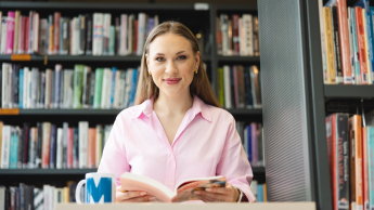 International Business | Uniwersytet WSB Merito Opole: Główna grafika: Opole - studia I stopnia - specjalność International Business - Studentka siedząca w bibliotece