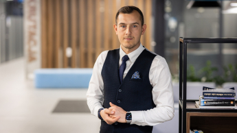 Zarządzanie projektem – Akademia Project Managera | Uniwersytet WSB Merito Opole: Główna grafika: Opole - studia podyplomowe - Zarządzanie projektem – Akademia Project Managera - Mężczyzna stojący obok regału na książki