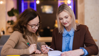 Zarządzanie w oświacie | Uniwersytet WSB Merito Opole: Główna grafika: Opole - studia podyplomowe - Zarządzanie w oświacie - Dwie kobiety przeglądające notatki