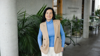 Zarządzanie kryzysowe oraz ciągłość działania | Studia podyplomowe w Opolu | Uniwersytet WSB Merito Opole: Główna grafika: Opole - studia podyplomowe - Zarządzanie kryzysowe oraz ciągłoś działania - Kobieta ubrana w niebieską bluzkę, stoi na korytarzy biblioteki