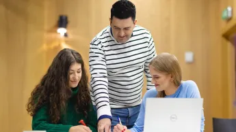 Doradztwo podatkowe | Studia II stopnia w Opolu | Uniwersytet WSB Merito Opole: Główna grafika: Opole - studia II stopnia - specjalność Doradztwo podatkowe - dwie studentki pracujące nad projektem pod okiem wykładowcy