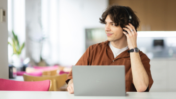 Inżynieria zarządzania procesami produkcyjnymi | Studia I stopnia w Opolu | Uniwersytet WSB Merito Opole: Główna grafika: Opole - studia I stopnia - specjalność Inżynieria zarządzania procesami produkcyjnymi - Chłopak korzystający z laptopa, ma założone słuchawki na uszy