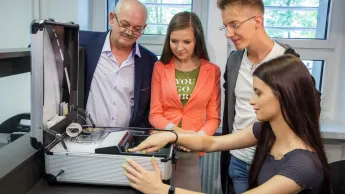 Inżynieria systemów logistycznych | Uniwersytet WSB Merito Opole: Główna grafika: Opole - studia I stopnia - specjalność Inżynieria systemów logistycznych - Grupa studentów korzystająca z narzędzi kierunkowych pod okiem wykładowcy
