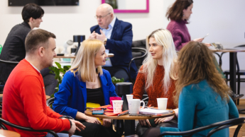 Zarządzanie kryzysowe i pomoc humanitarna | Studia II stopnia ze studiami podyplomowymi  | Uniwersytet WSB Merito Opole: Główna grafika: Opole - Studia II stopnia z podyplomowymi - specjalność Zarządzanie kryzysowe i pomoc humanitarna - Grupa osób siedząca w kawiarni