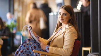 Pedagogika resocjalizacyjna z socjoterapią | Studia II stopnia ze studiami podyplomowymi  | Uniwersytet WSB Merito Opole: Główna grafika: Opole - studia II stopnia z podyplomowymi - specjalność Pedagogika resocjalizacyjna z socjoterapią - Kobieta siedząca w kawiarni, przegląda notatki