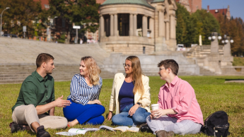 Kontynuuj studia | Uniwersytet WSB Merito Opole: Grupa studentów siedząca na trawie