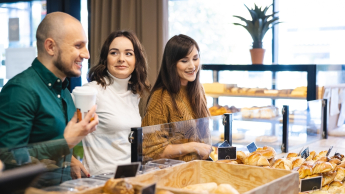 Wyniki wyszukiwania | Uniwersytet WSB Merito Opole: Główna grafika: Opole - studia II stopnia- Dietetyka - studenci stoją w piekarni i patrzą na gablotę z pieczywem