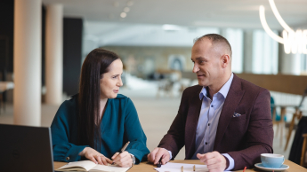 Księgowość i płace w przedsiębiorstwie | Studia podyplomowe w Opolu | Uniwersytet WSB Merito Opole: Główna grafika: Opole - studia podyplomowe -Księgowość i płace w przedsiębiorstwie- uczestnicy studiów podyplomowych siedzą przy biurku i rozmawiają 