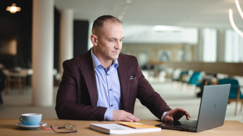 Kompetencje przyszłości - przewaga w świecie zmian | Studia podyplomowe w Opolu | Uniwersytet WSB Merito Opole: Główna grafika: Opole- studia podyplomowe- Kompetencje Przyszłości - Przewaga w Świecie Zmian- uczestnik studiów podyplomowych siedzi przy biurku i spogląda w laptopa