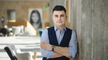 Zarządzanie i automatyzacja procesów w biznesie | Studia podyplomowe w Opolu | Uniwersytet WSB Merito Opole: Główna grafika: Opole - studia podyplomowe -Zarządzanie i automatyzacja procesów w biznesie- uczestnik studiów podyplomowych stoi oparty o ścianę z założonymi rękami