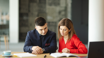 E-commerce i zarządzanie platformami sprzedażowymi | Studia podyplomowe w Opolu | Uniwersytet WSB Merito Opole: Główna grafika: Opole - studia podyplomowe - E-commerce i zarządzanie platformami sprzedażowymi- uczestnicy studiów podyplomowych siedzą przy biurku i analizują treści z notatnika