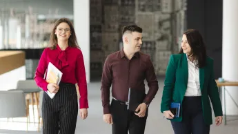 HR menedżer | Studia podyplomowe w Opolu | Uniwersytet WSB Merito Opole: Główna grafika: Opole - studia podyplomowe -HR menedżer- uczestnicy studiów podyplomowych idą korytarzem rozmawiając ze sobą