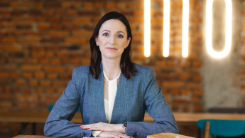 Księgowość i płace w przedsiębiorstwie | Studia podyplomowe w Opolu | Uniwersytet WSB Merito Opole: Główna grafika: Opole - studia podyplomowe -Księgowość i płace w przedsiębiorstwie- uczestniczka studiów podyplomowych siedzi przy biurku i patrzy przed siebie