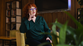 Analiza i informatyka śledcza | Uniwersytet WSB Merito Opole: Główna grafika: Opole - studia podyplomowe - Analiza i informatyka śledcza- uczestniczka studiów podyplomowych siedzi na fotelu i spogląda za okno