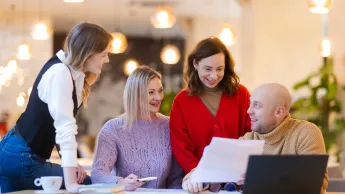 E-commerce i zarządzanie platformami sprzedażowymi | Uniwersytet WSB Merito Opole: Główna grafika: Opole - studia podyplomowe - E-commerce i zarządzanie platformami sprzedażowymi- uczestnicy studiów podyplomowych siedzą i stoją przy biurku i analizują treści z kartki