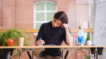 Dietetyka pediatryczna | Uniwersytet WSB Merito Opole: Studentka siedzi i czyta książkę